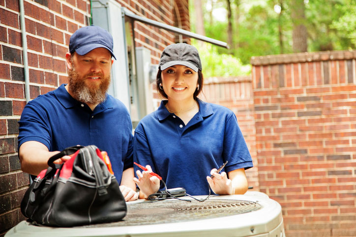 Technicians diagnosing a/c unit