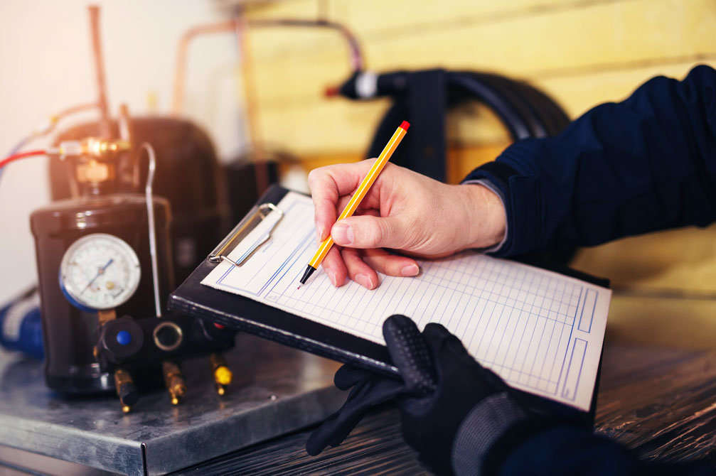 Technician with clipboard diagnosing a/c unit