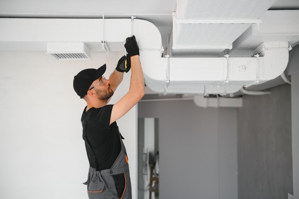 Worker cleaning air ducts